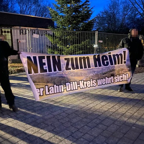 Dunkel gekleidete Männer mit großem Banner auf dem steht: Nein zum Heim, Der Lahn-Dill-Kreis wehrt sich