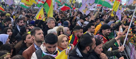 Teilnehmende in kurdischen Farben Rot, Gelb und Grün