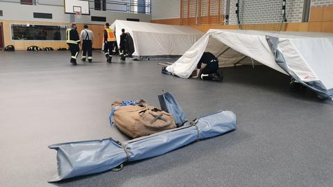 Zelte, die in einer Turnhalle aufgebaut werden