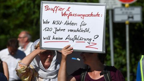 Zwei Frauen tragen auf einer Demonstration ein Schild mit, wer die NSU Akten verschließt, will kein Aufklärung
