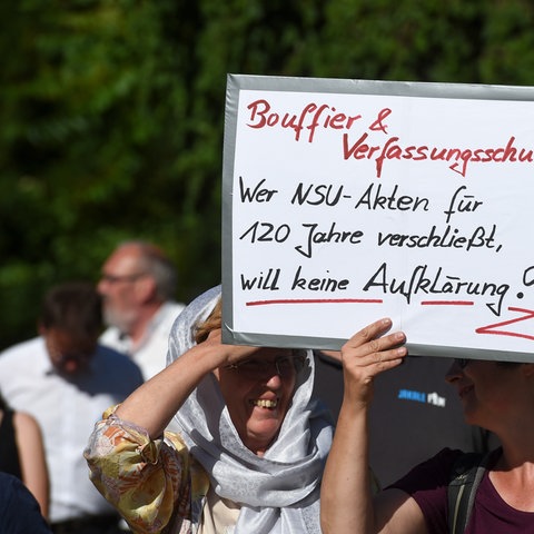 Zwei Frauen tragen auf einer Demonstration ein Schild mit, wer die NSU Akten verschließt, will kein Aufklärung