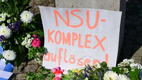 "NSU-Komplex auflösen" steht auch einem Karton, der inmitten das Blumenmeer an einem Gewdenkort gestellt wurde.