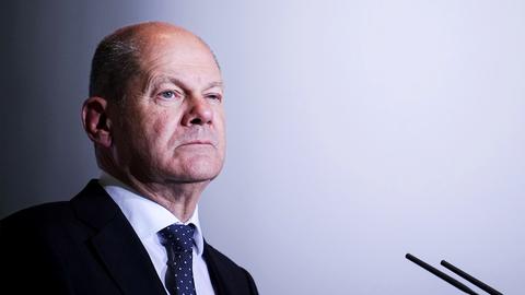 Foto von Olaf Scholz - vor sich ein Mikrofon.