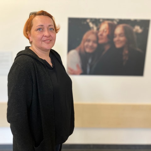 Filiz Taraman-Schmorde, Schwester eines verstorbenen Organspenders, vor einem Foto in der Ausstellung über Organspender im Uniklinikum Gießen