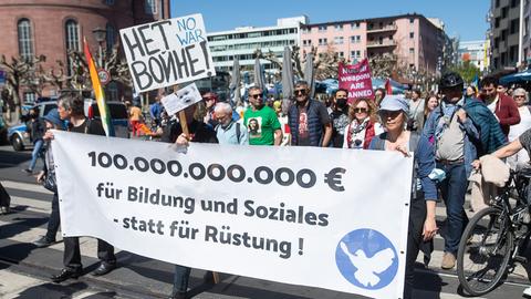 "100.000.000.000 Euro für Bildung und Soziales - statt für Rüstung" steht während der Frankfurter Abschlusskundgebung auf einem Plakat von Demonstranten.