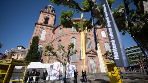 Vor der Paulskirche in Frankfurt sind Bäume mit bunten Bändern geschmückt.