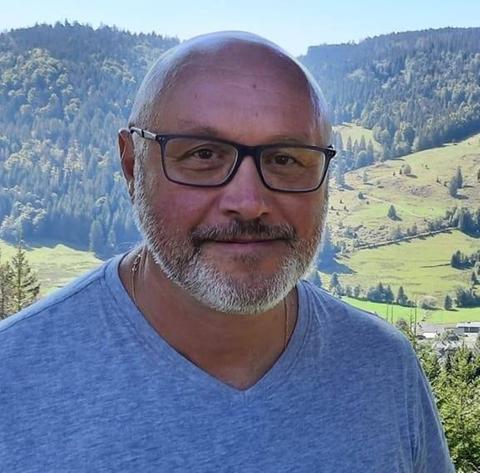 Ein Mann vor einer hügeligen Landschaft