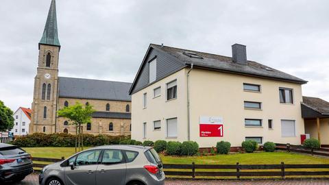 Die Gebäude Pfarrhaus Kalbach und die Kirche daneben aus der Ferne fotografiert.