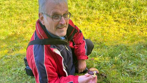 Mann mit Pilzen in der Hand