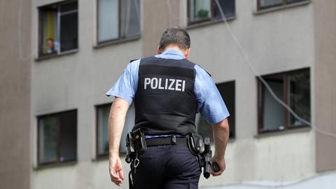 Ein Polizist geht mit gesenktem Haupt.