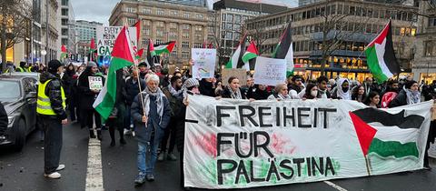 Teilnehmer einer Pro-Palästina-Demo am Tag vor Heiligabend in der Frankfurter Innenstadt mit Palästina-Flaggen und dem Spruchband "Freiheit für Palästina"