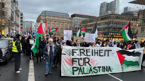 Teilnehmer einer Pro-Palästina-Demo am Tag vor Heiligabend in der Frankfurter Innenstadt mit Palästina-Flaggen und dem Spruchband "Freiheit für Palästina"