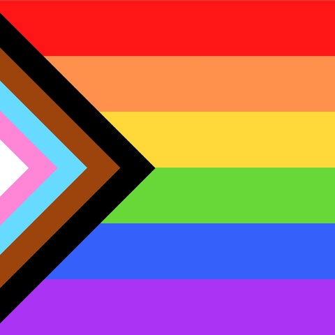 Die Regenbogenflagge enthält auf der linken Seite einen Keil in Farben der Trans-Pride-Flagge und in braun und schwarz, den Farben der marginalisierten Communities.