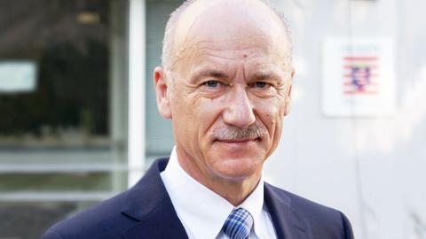 Mann im Anzug (Portrait), der in die Kamera blickt.