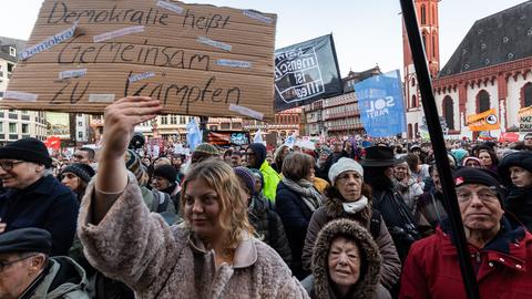 "Demokratie heißt Gemeinsam zu kämpfen" steht auf einem Schild, das eine Frau bei der Kundgebung "Frankfurt steht auf für Demokratie" hochhält. 