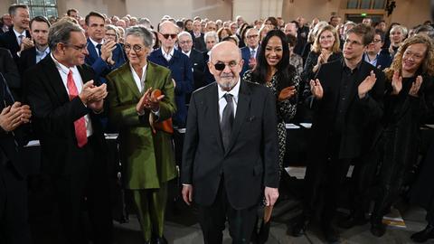 Der britisch-indische Autor Salman Rushdie (M) bekommt zu Beginn der Verleihung des Friedenspreis des Deutschen Buchhandels in der Paulskirche stehenden Applaus.