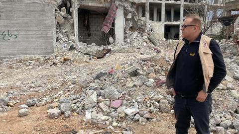 Safour Labanieh steht vor einem eingestürzten Haus in Syrien.