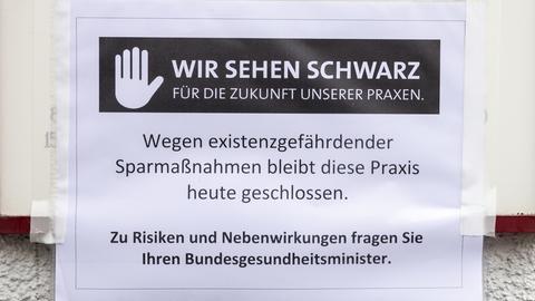 Ausdruck, auf dem steht: "Wir sehen schwarz für die Zukunft unserer Praxen. Wegen existenzgefährdender Sparmaßnahmen bleibt diese Praxis heute geschlossen. Zu Risiken und Nebenwirkungen fraen Sie Ihren Bundesgesundheitsminister."