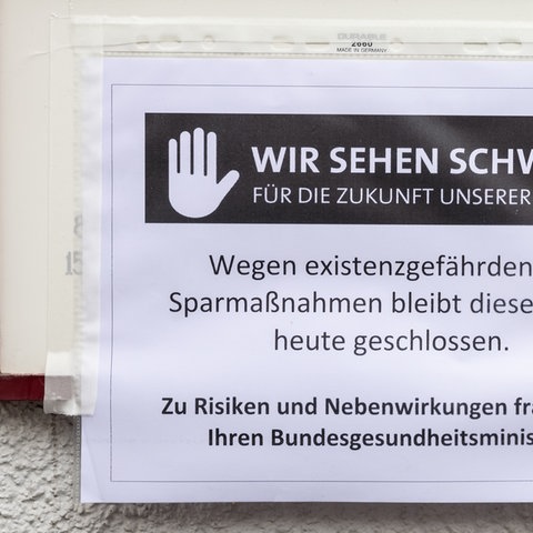 Ausdruck, auf dem steht: "Wir sehen schwarz für die Zukunft unserer Praxen. Wegen existenzgefährdender Sparmaßnahmen bleibt diese Praxis heute geschlossen. Zu Risiken und Nebenwirkungen fraen Sie Ihren Bundesgesundheitsminister."