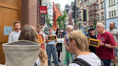 Mitglieder der Seebrücke bei Protestaktion in Marburg mit Schildern und Fahnen 