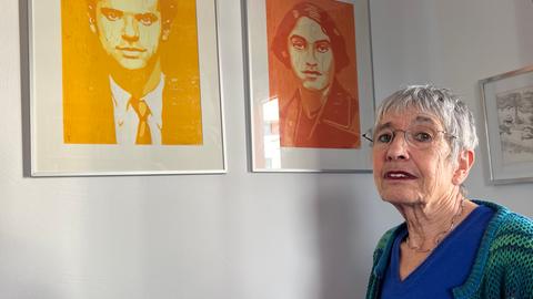 Silvia Gingold blickt auf zwei Linoldrucke, die in ihrem Arbeitszimmer an der Wand hängen. Sie zeigen ihre Eltern Peter und Ettie Gingold.