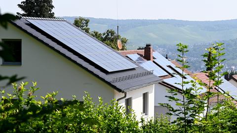 Dächer mit Solaranlagen auf Häusern an einem Hang. 