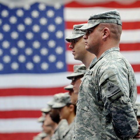 US-Soldaten in Tarnkleidung vor der US-Flagge