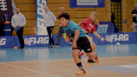 Schüler beim Flag-Football-Wettbewerb im München - Spiel in einer Halle - im Hintergrund Werbung DKB und NFL