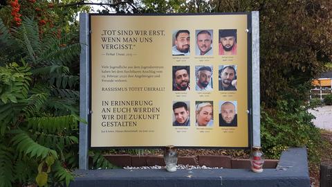 Eine Gedenkstele mit Bilder der Getöteten steh am Jugenzentrum in Hanau mit der Inschrift: „Tot sind wir erst, wenn man uns vergisst“, „Rassismus tötet überall“, „In Erinnerung an Euch werden wir die Zukunft gestalten“.