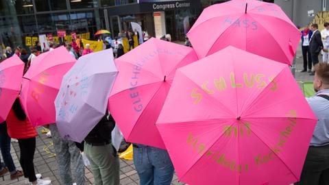 Mitglieder unterschiedlicher katholischer Jugendverbände halten zu Beginn der vierten Synodalversammlung der katholischen Kirche in Deutschland im Congress Center Messe Frankfurt vor dem Eingang Schirme mit Botschaften wie "Meine Kirche ist Bunt" zur Unterstützung der Vielfalt in der katholischen Kirche hoch. 