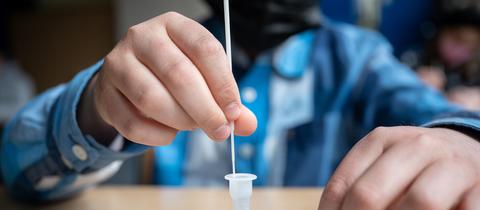 Ein Schüler führt in einer Klasse in Rheinland-Pfalz einen Corona-Schnelltest an sich selbst durch. (dpa)
