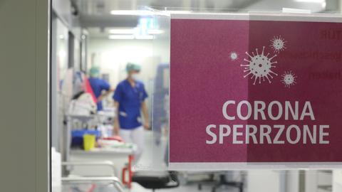 "Corona Sperrzone" steht auf einem Schild, das am Eingang einer Covid-19 Intensivstation an der Tür klebt. 