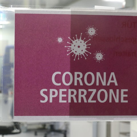 "Corona Sperrzone" steht auf einem Schild, das am Eingang einer Covid-19 Intensivstation an der Tür klebt. 