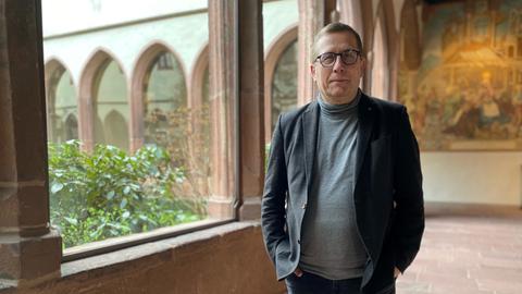 Kirchenrechtsexperte Thomas Schüller steht im Säulengang des Stadtarchivs Frankfurt