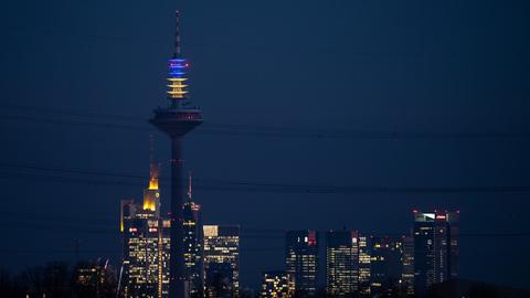 Der Frankfurter Europaturm leuchtet aus Solidarität mit der Ukraine in deren Landesfarben blau und gelb.
