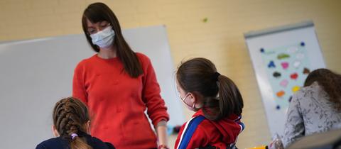 Lehrerin vor Schülerinnen in Klassenraum