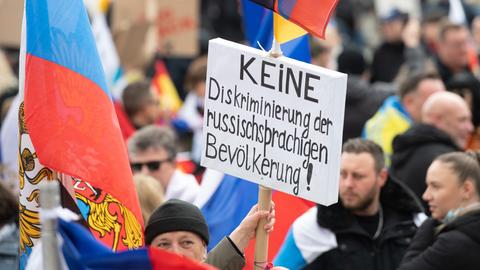 Teilnehmer einer pro-russischen Demo in Frankfurt halten ein Schild hoch, auf dem steht: "Keine Diskriminierung russischsprachiger Menschen!