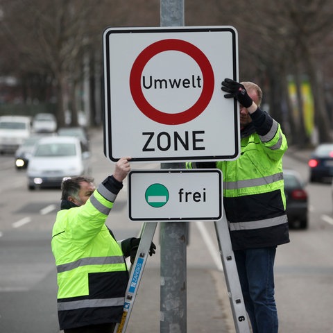 Ein Schild mit der Aufschrift Umwelt-Zone wird aufgehängt.