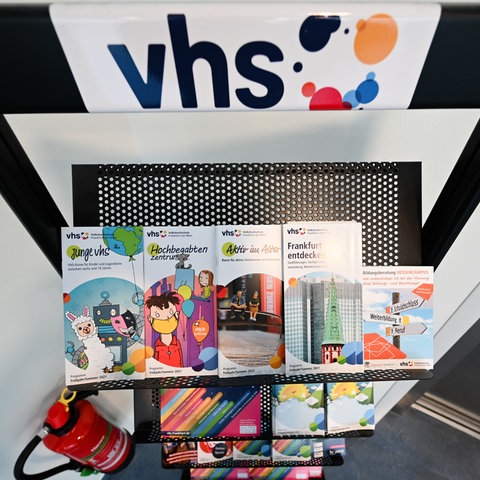 Logo der Volkshochschule vhs - davor ein Schriftenständer