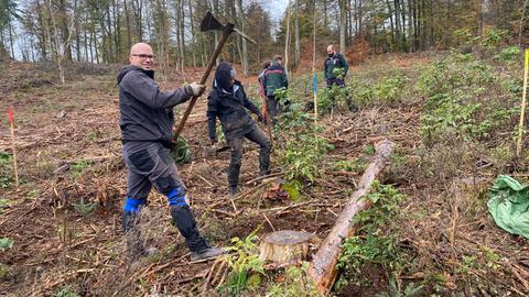 Mann mit Hacke im Wald