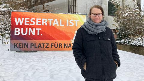 Silke Jordan, Vorsitzende des Vereins "Wesertal ist bunt" vor dem Haus. Auf einem großen Plakat steht neben dem Vereinsnamen "Kein Platz für Nazis"