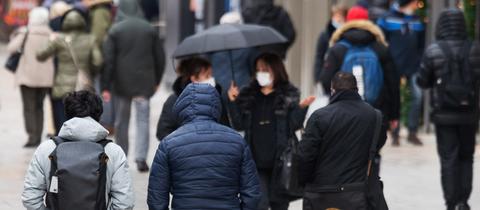 Passanten gehen bei Regenwetter über die Zeil in Frankfurt am Main. 
