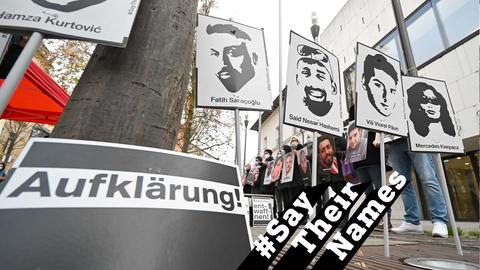 Mahnwache vor dem Landtag. Menschen halten Schilder mit den Portraits der Opfer hoch. Im Vordergrund ein Plakat mit der Aufschrift "Aufklärung".