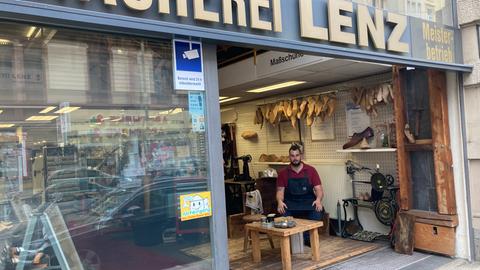 Alexander Dohn sitzt im Schaufenster der Schuhmacherei Lenz, die er gemeinsam mit seinem Vater führt.