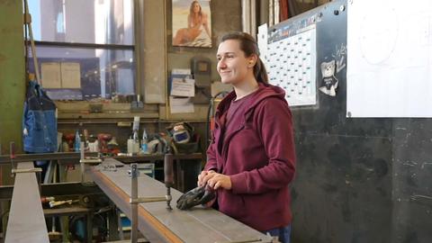 Metallbauerin Julia Peters steht in ihrem Betrieb an einer Werkbank.