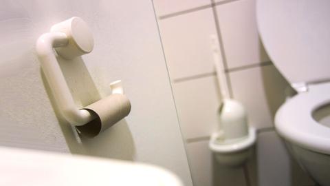 Leere Toilettenpapierrolle im WC einer Schule