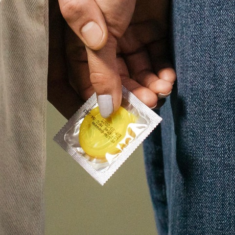 Ein Paar hält ein Kondom in den Händen