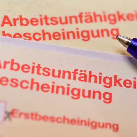 Arbeitsunfähigkeitsbescheinigung mit Kugelschreiber