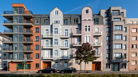 Vier Häuserfronten in verschiedenen Farben und Materialien
