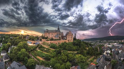 Marburg unter einem Gewitterhimmel mit einem Blitz
